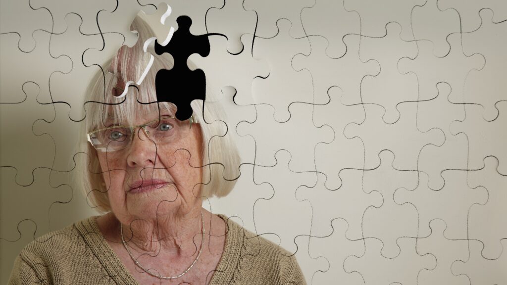 A puzzle of an older woman shows a piece missing on the top right of her head.