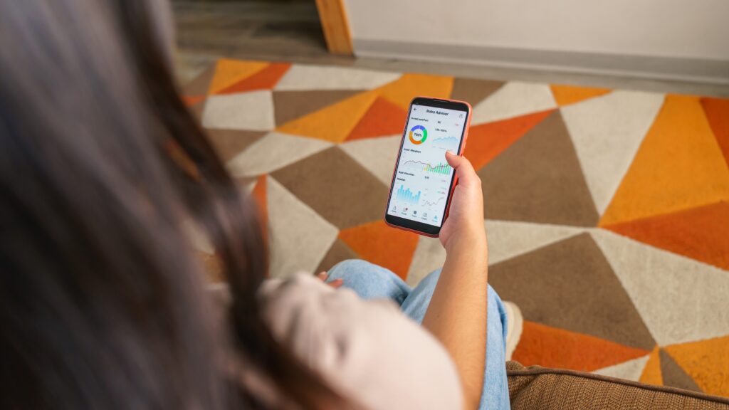 A woman checks her robo-adviser app on her phone.