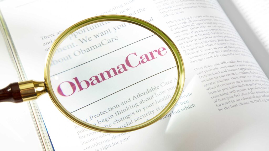 picture of a magnifying glass over a book about ObamaCare