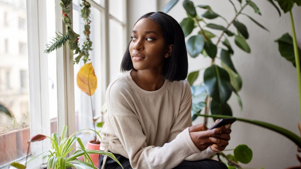 A young woman looks thoughtful as she looks out a window.