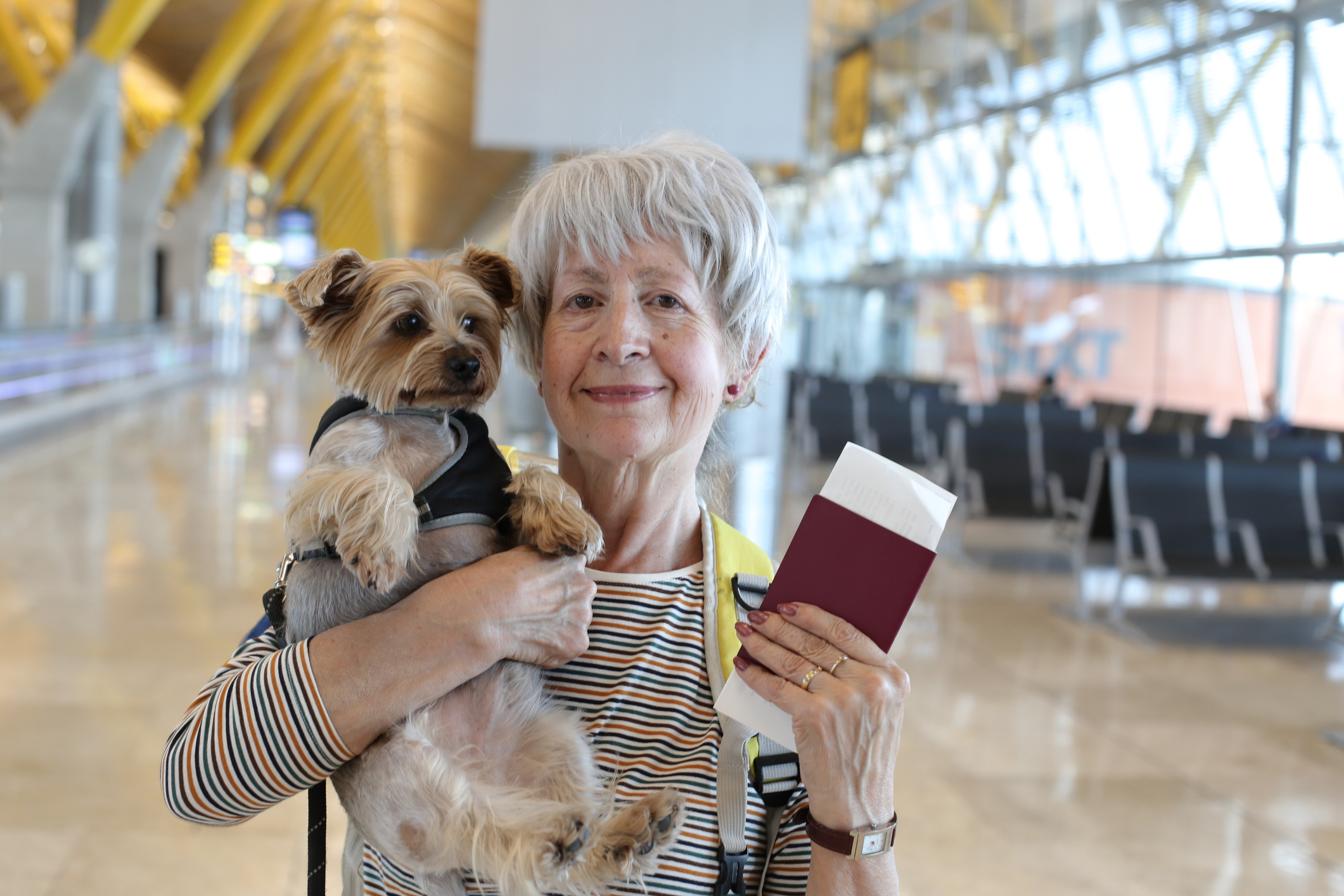 Woman traveling, holding her dog and travel documents