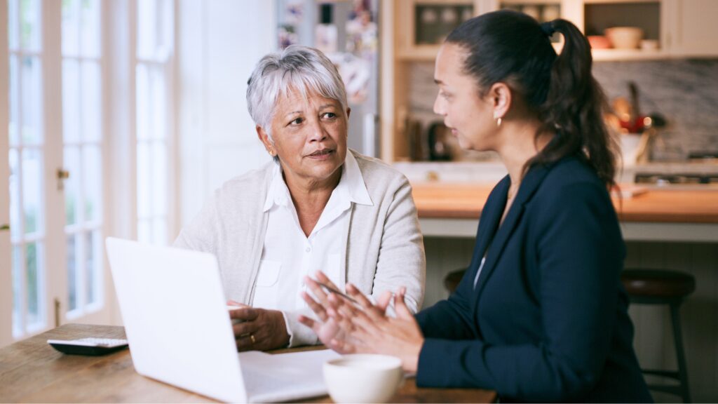 An older client listens as her financial adviser talks.