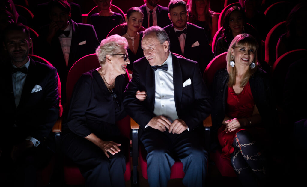 A couple is sitting in a theater waiting for the show to start.