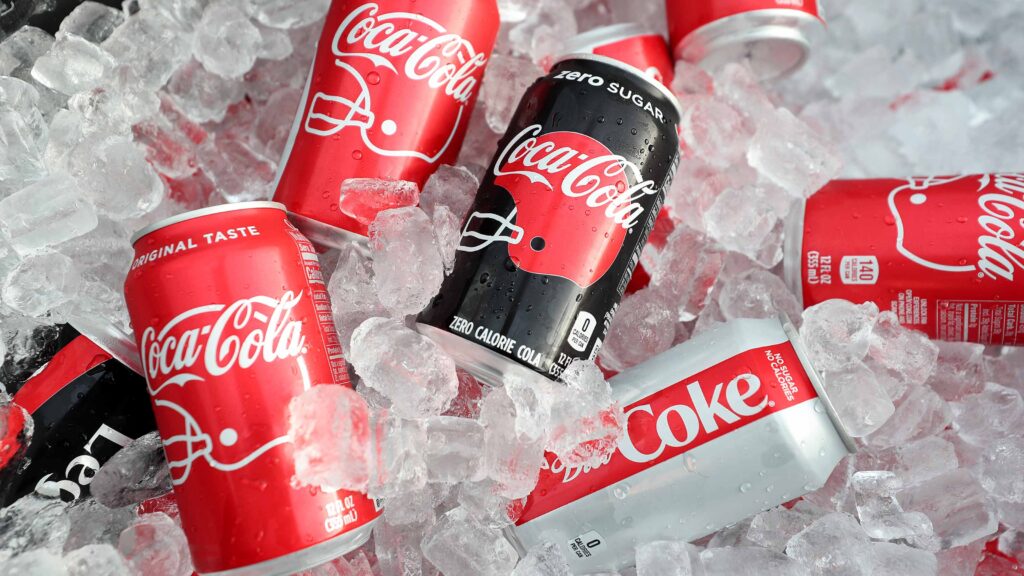 Various Coca-Cola and Coke Zero cans sitting in ice