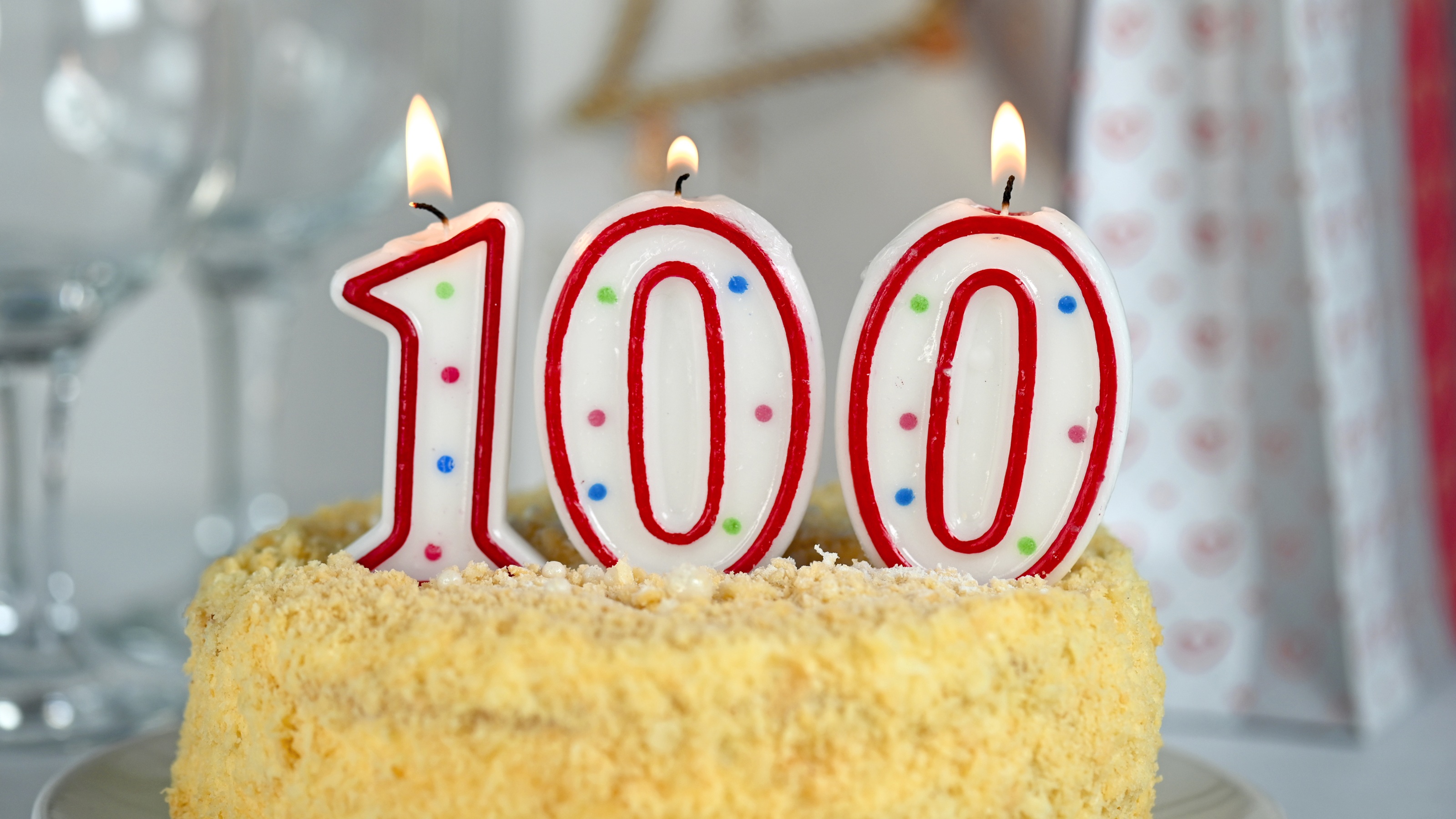 Bougies numérotées allumées sur un gâteau d'anniversaire pour une personne de 100 ans.