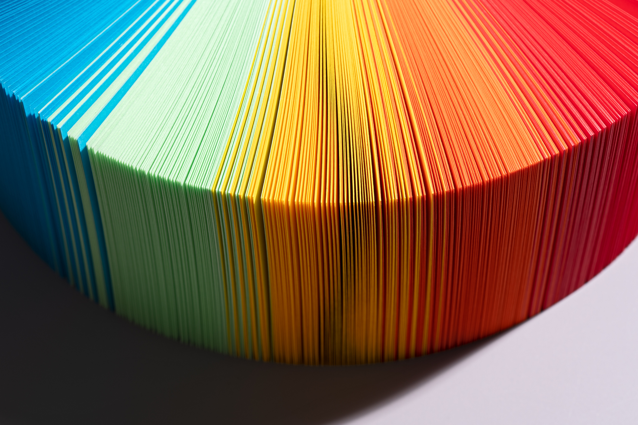 gradient color paper pages in shades of blue, green, yellow and red in a fan shape