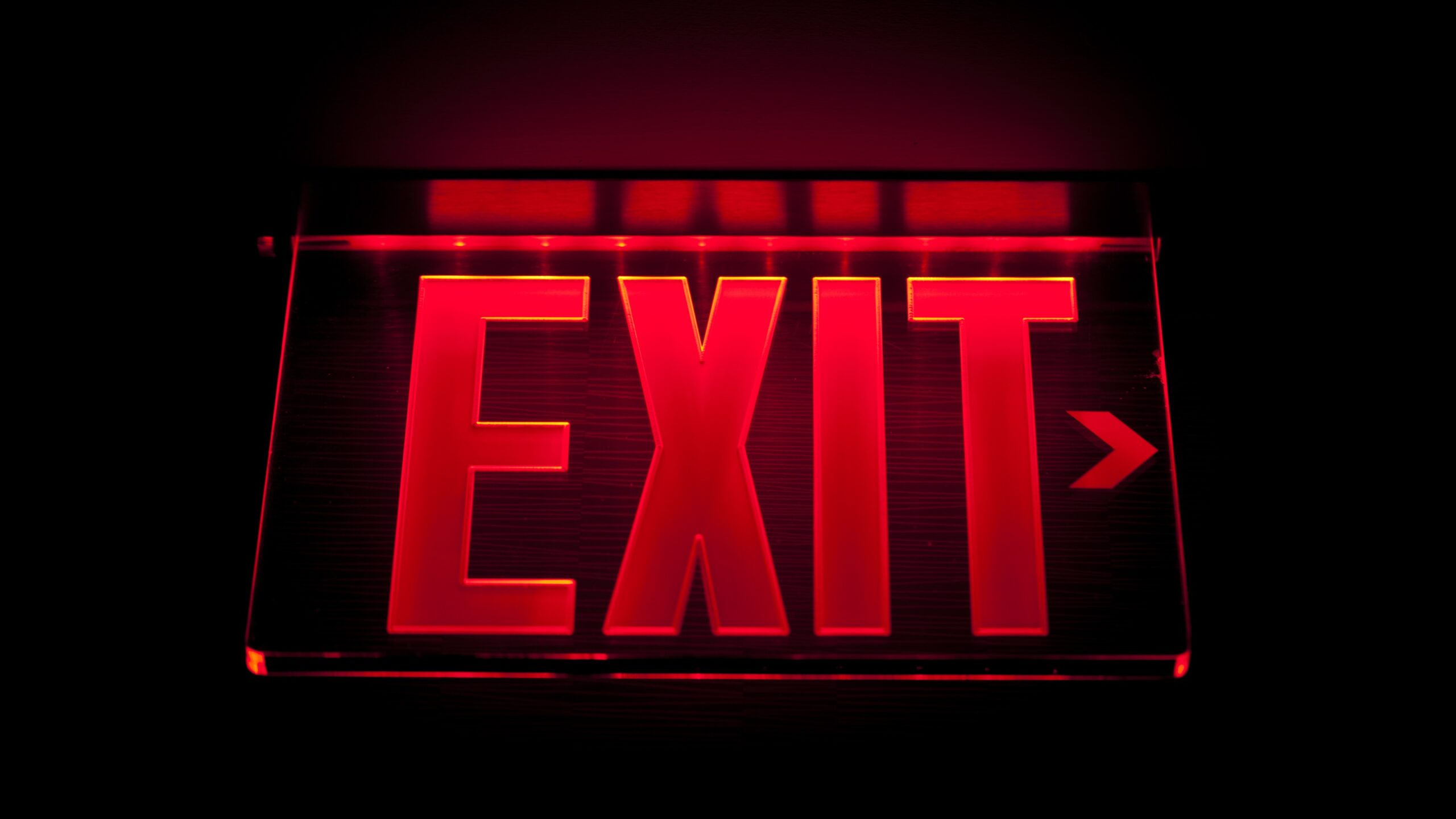 A red exit sign against a black background.