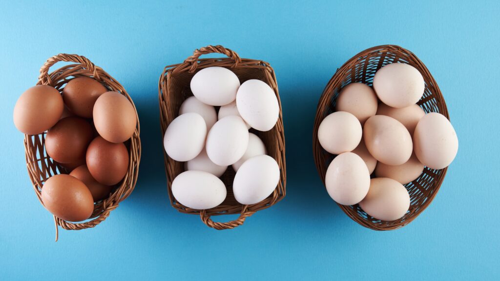 Three different shades of eggs in three different baskets.