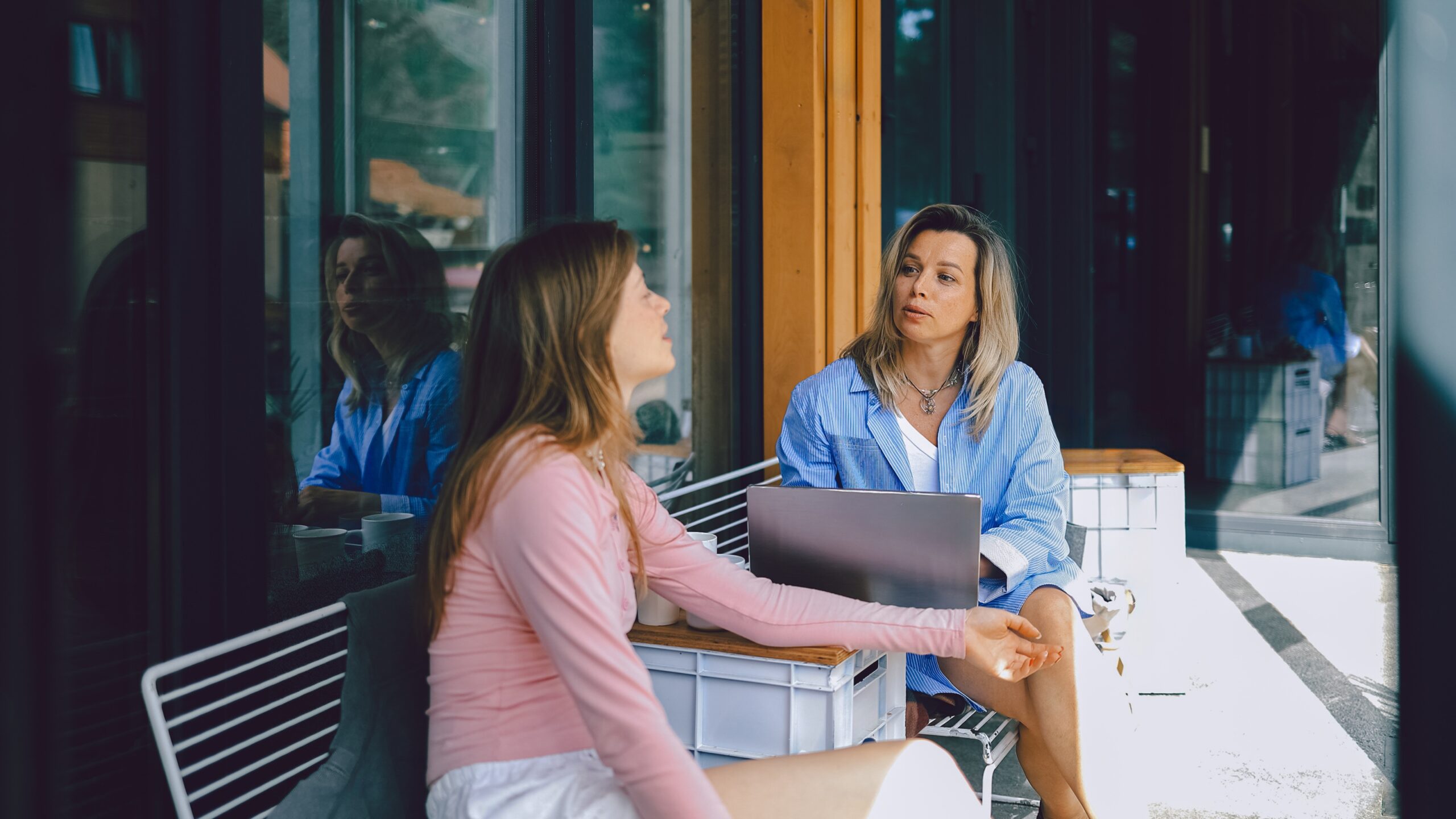 A young woman works with her financial adviser on a terrace.