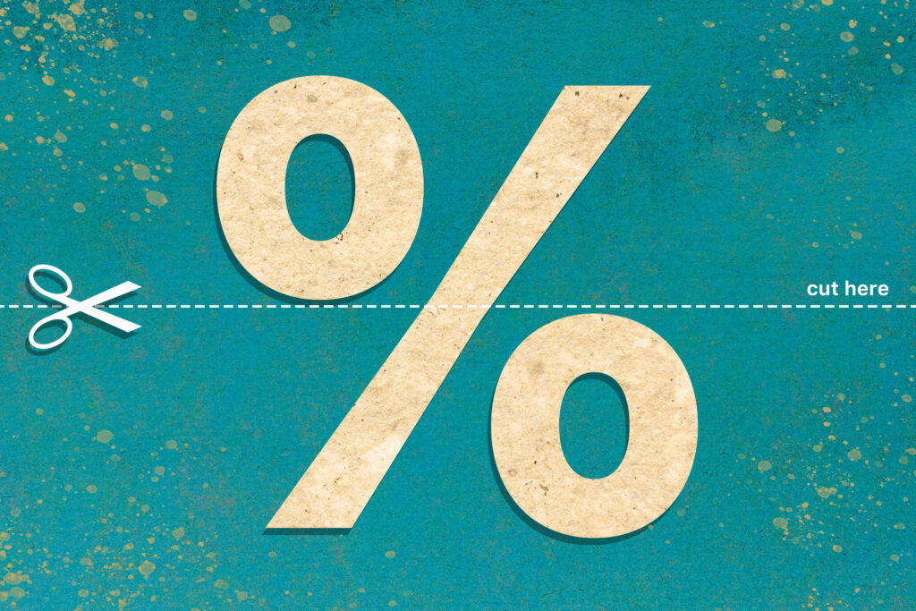 A representation of an interest rate cut. A percentage sign has a dotted line running through it. On one side is a pair of scissors and the other says "cut here."