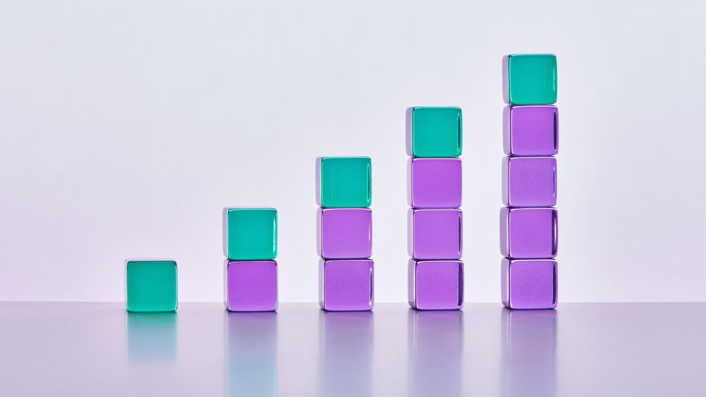 Five stacks of green and purple glass blocks that get progressively taller.