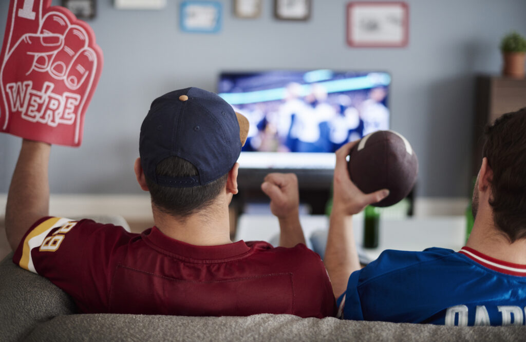 Two people watching football on a couch