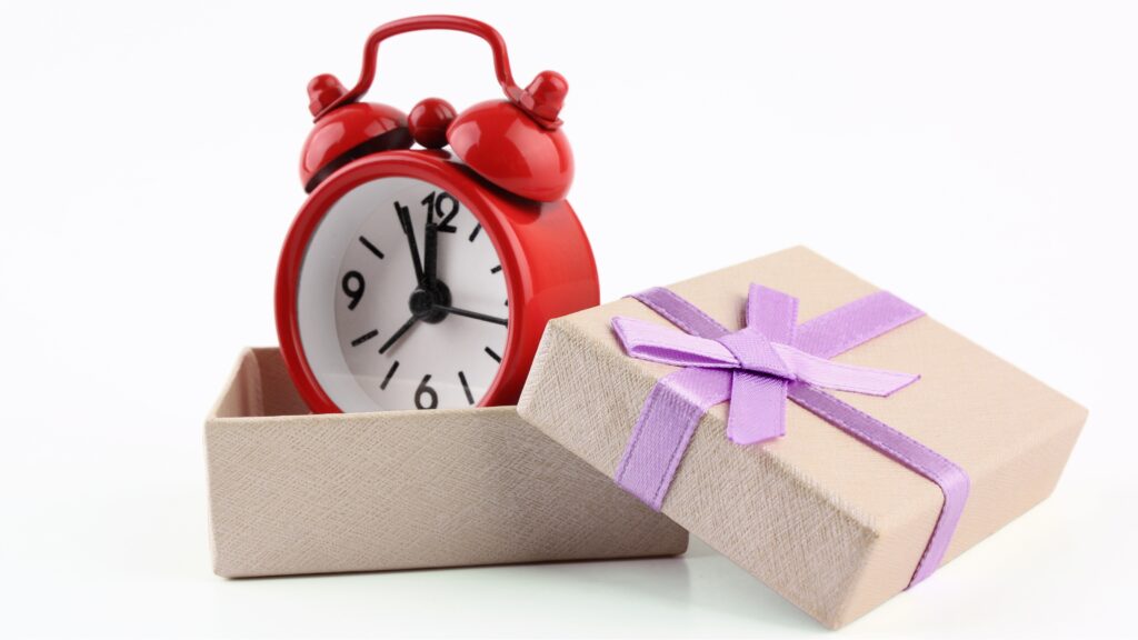 A clock in a gift box with the lid off.