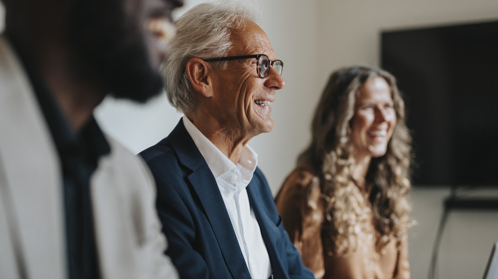 A retired businessman is at an office where he works as a consultant.