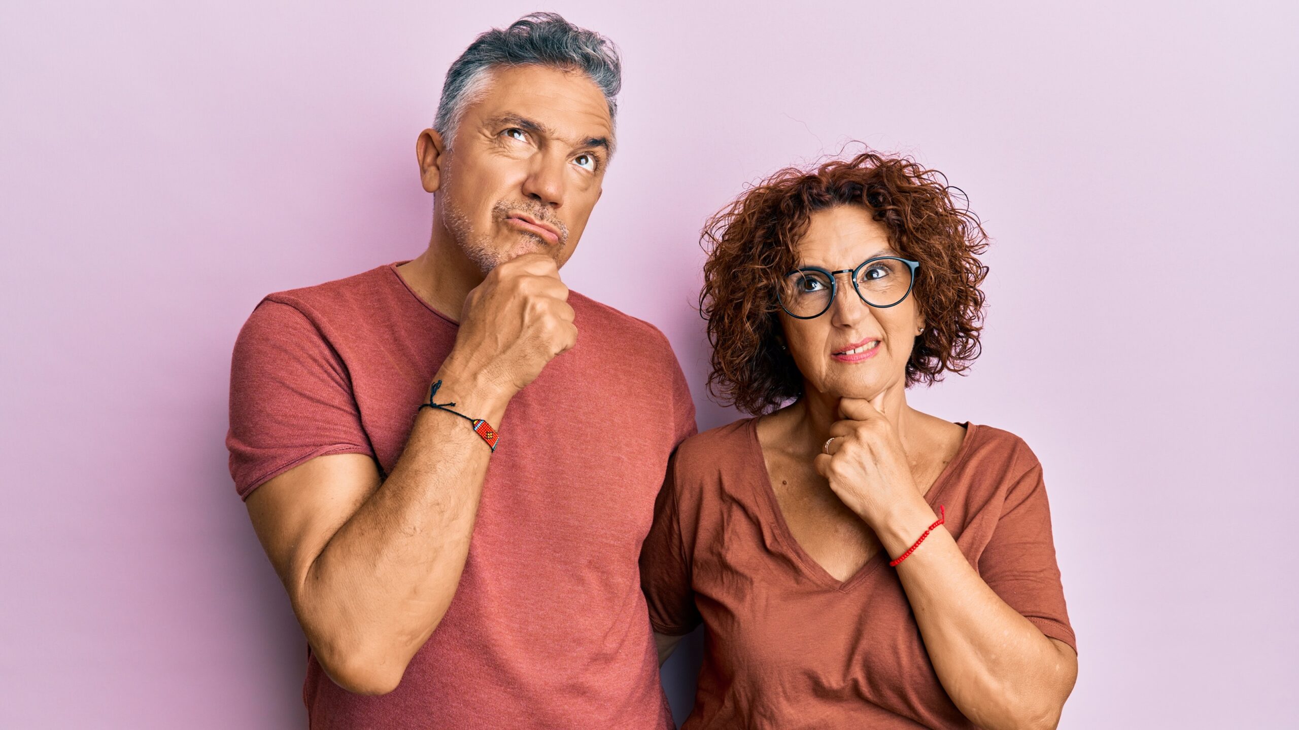 An older couple look into the distance with expressions of doubt.