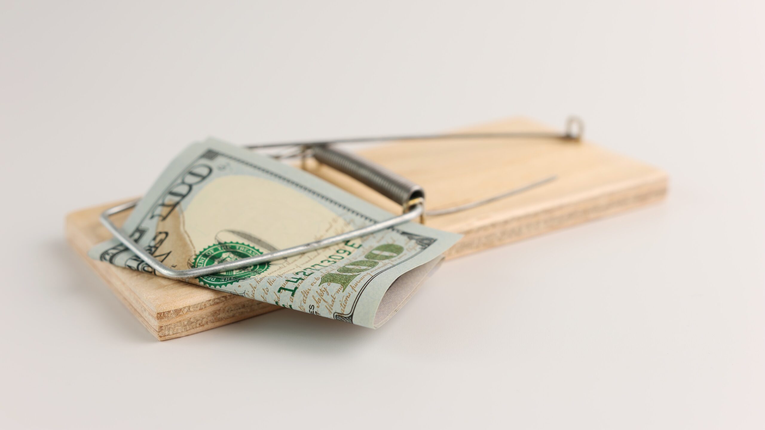 A hundred-dollar bill caught in a mousetrap.