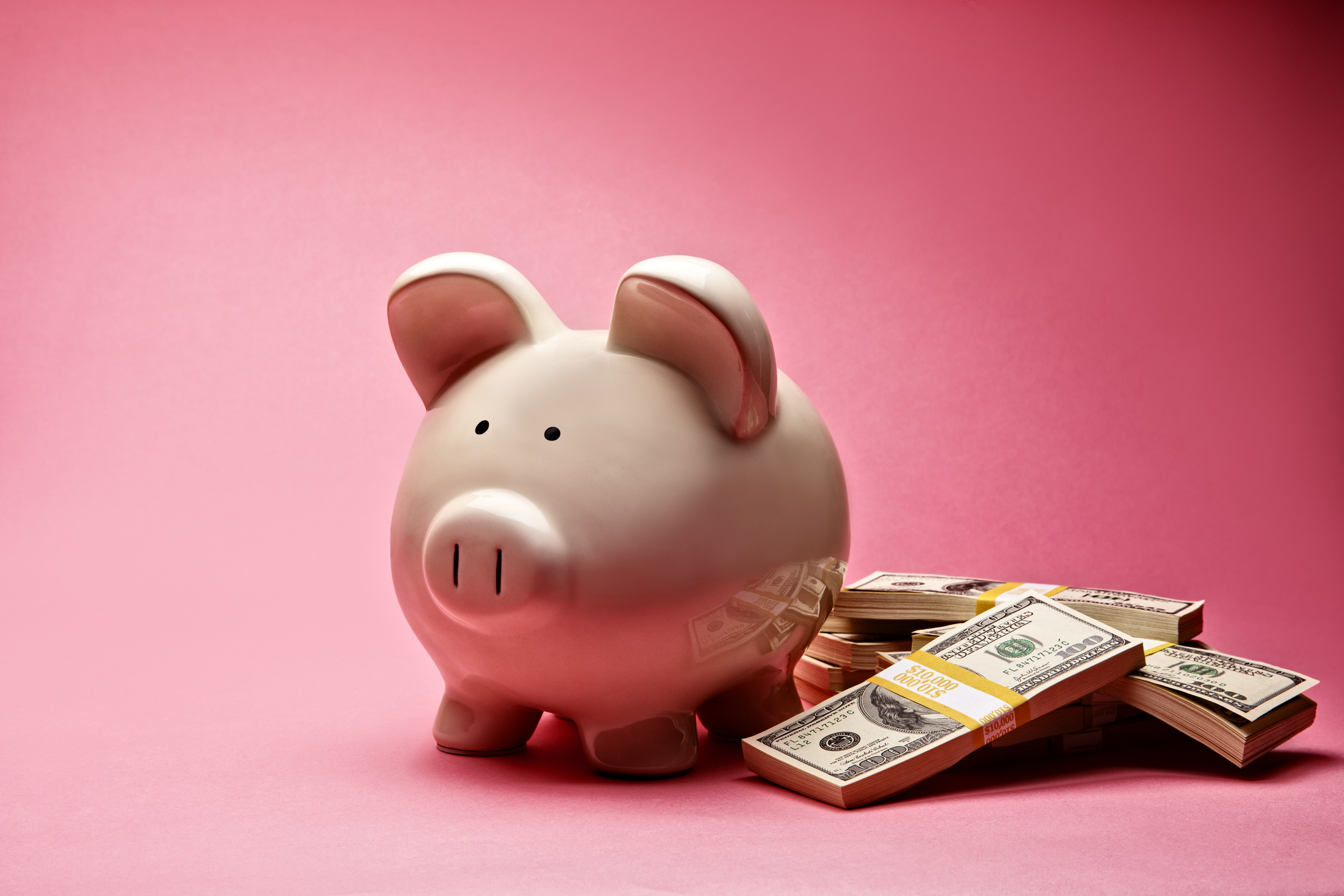 une tirelire à côté d'une pile de billets d'un dollar