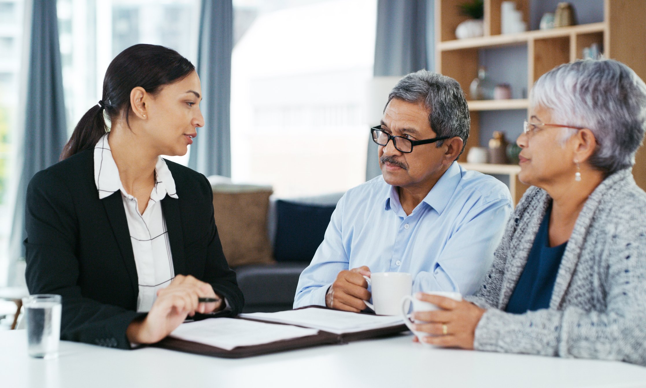 Un couple discute de ses options d’assurance habitation avec son courtier d’assurance