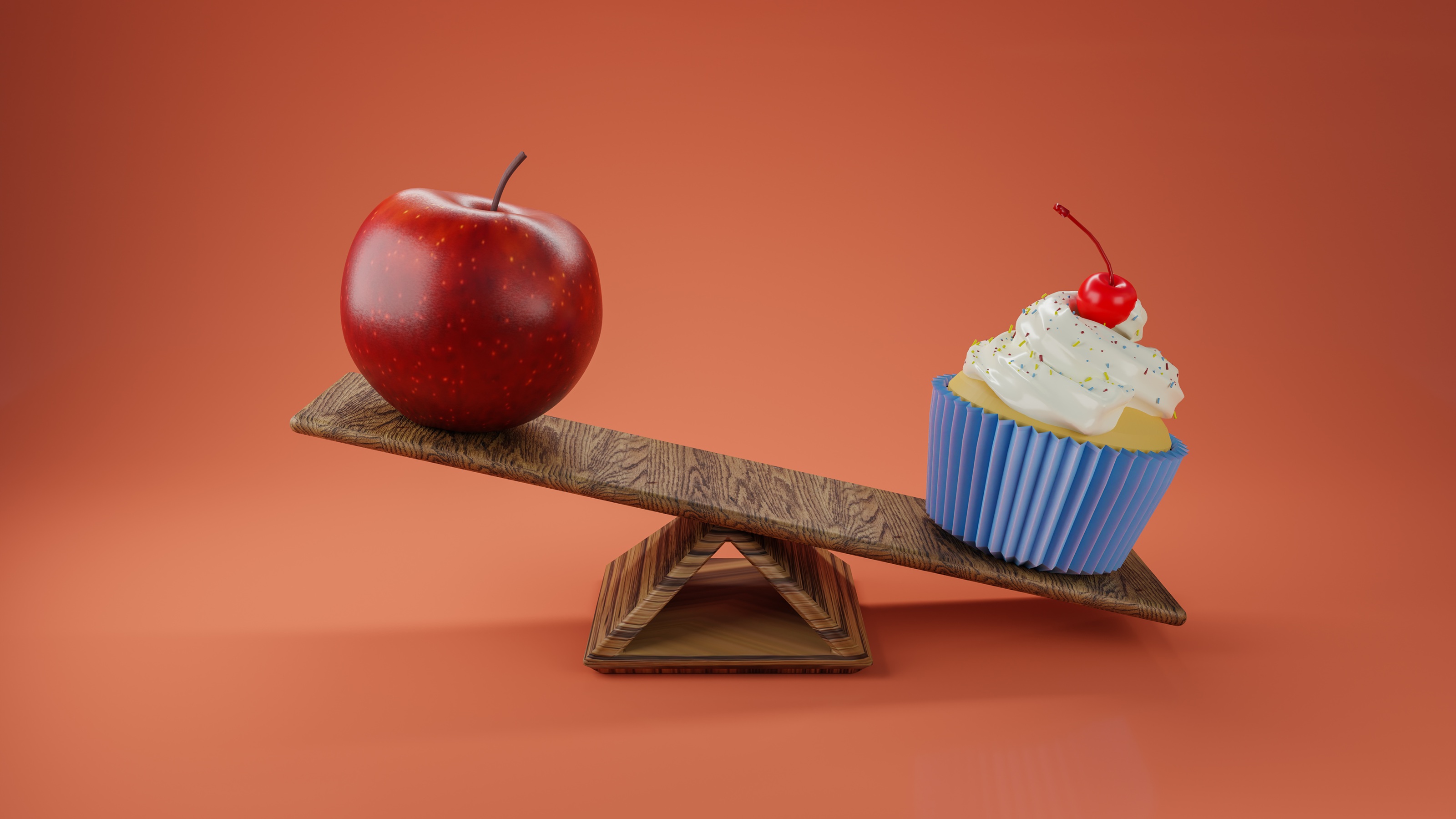 Une pomme et un cupcake sur une balançoire, le cupcake dépassant la pomme.