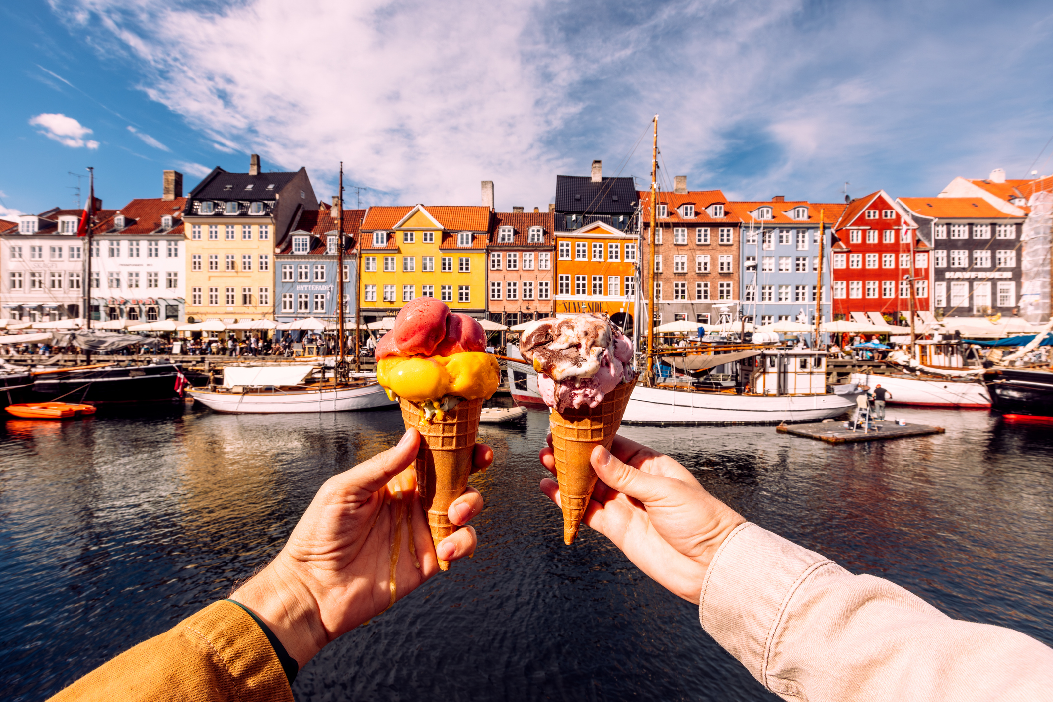 Deux personnes détenant des glaces colorées près du port de Nyhavn à Copenhague, Danemark