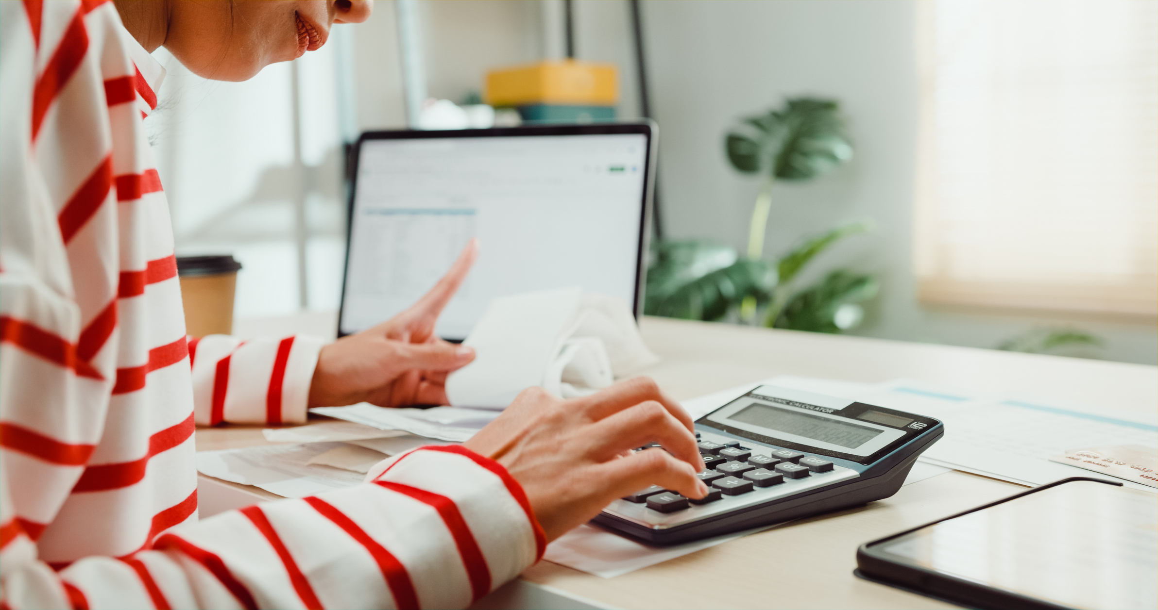 Une femme utilisant une calculatrice assise à un bureau