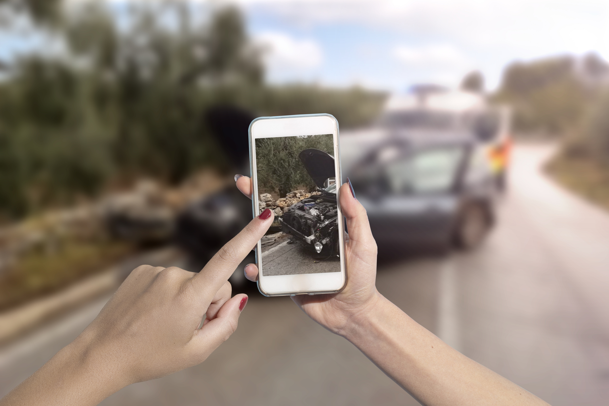 une personne prenant une photo sur son téléphone d'un accident de voiture