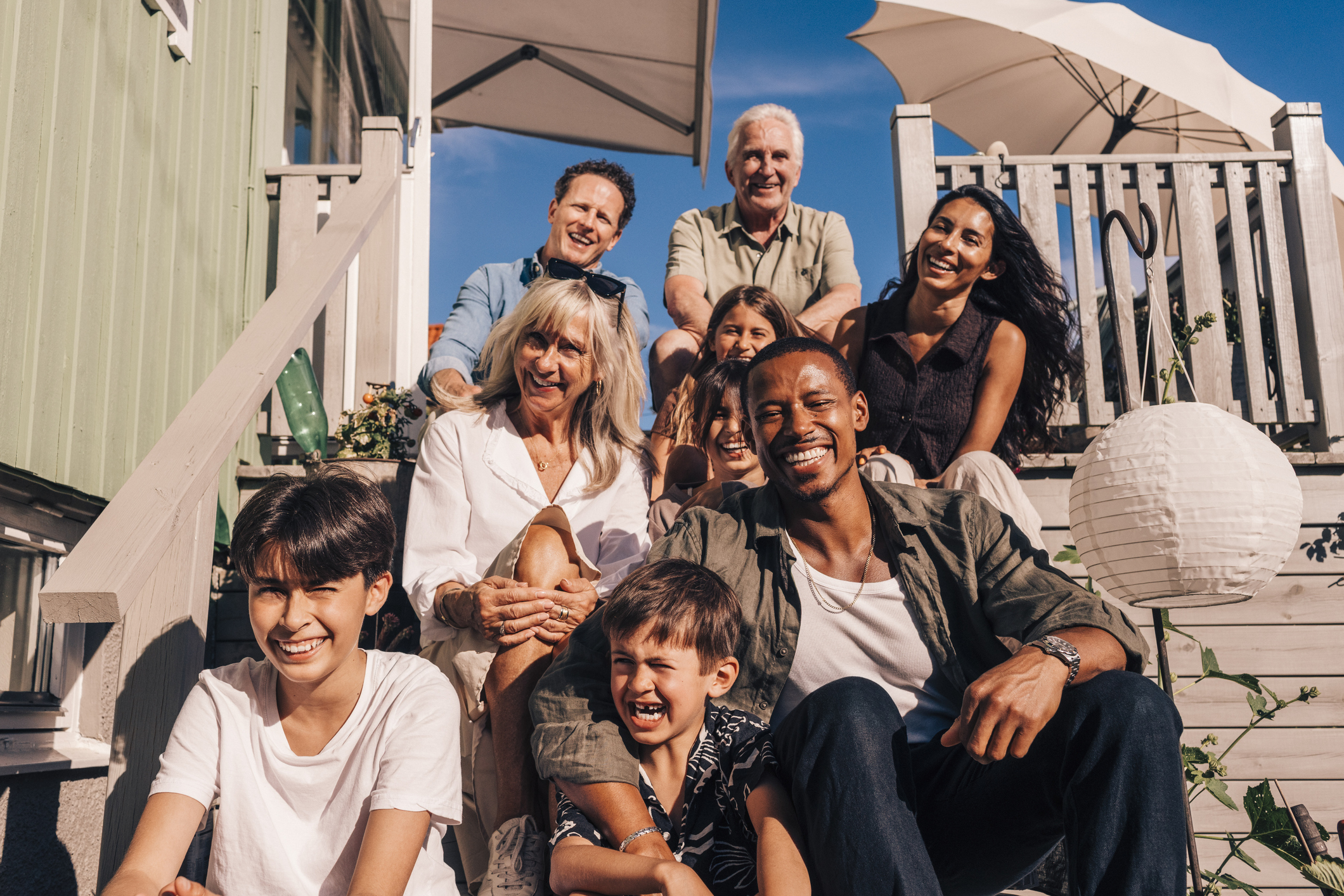 Famille assise sur les marches d’une maison de plage.