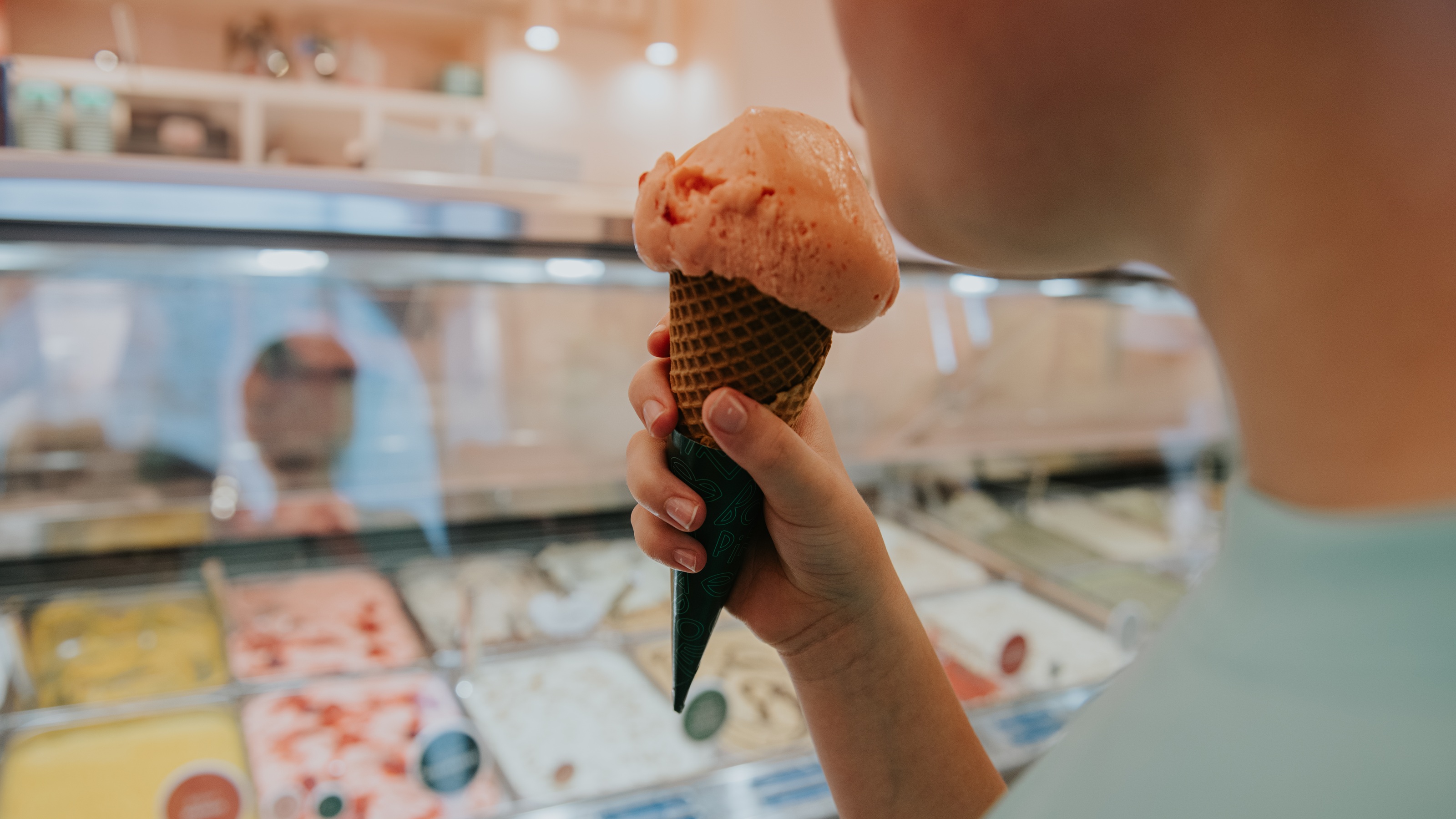 Un jeune garçon tient un cornet de glace dans un glacier.