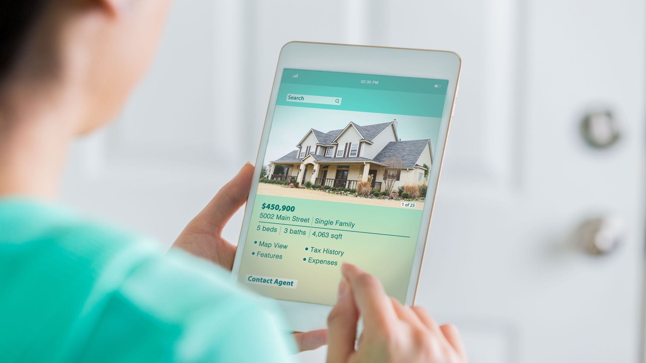 Une femme utilise une table numérique pour rechercher une nouvelle maison