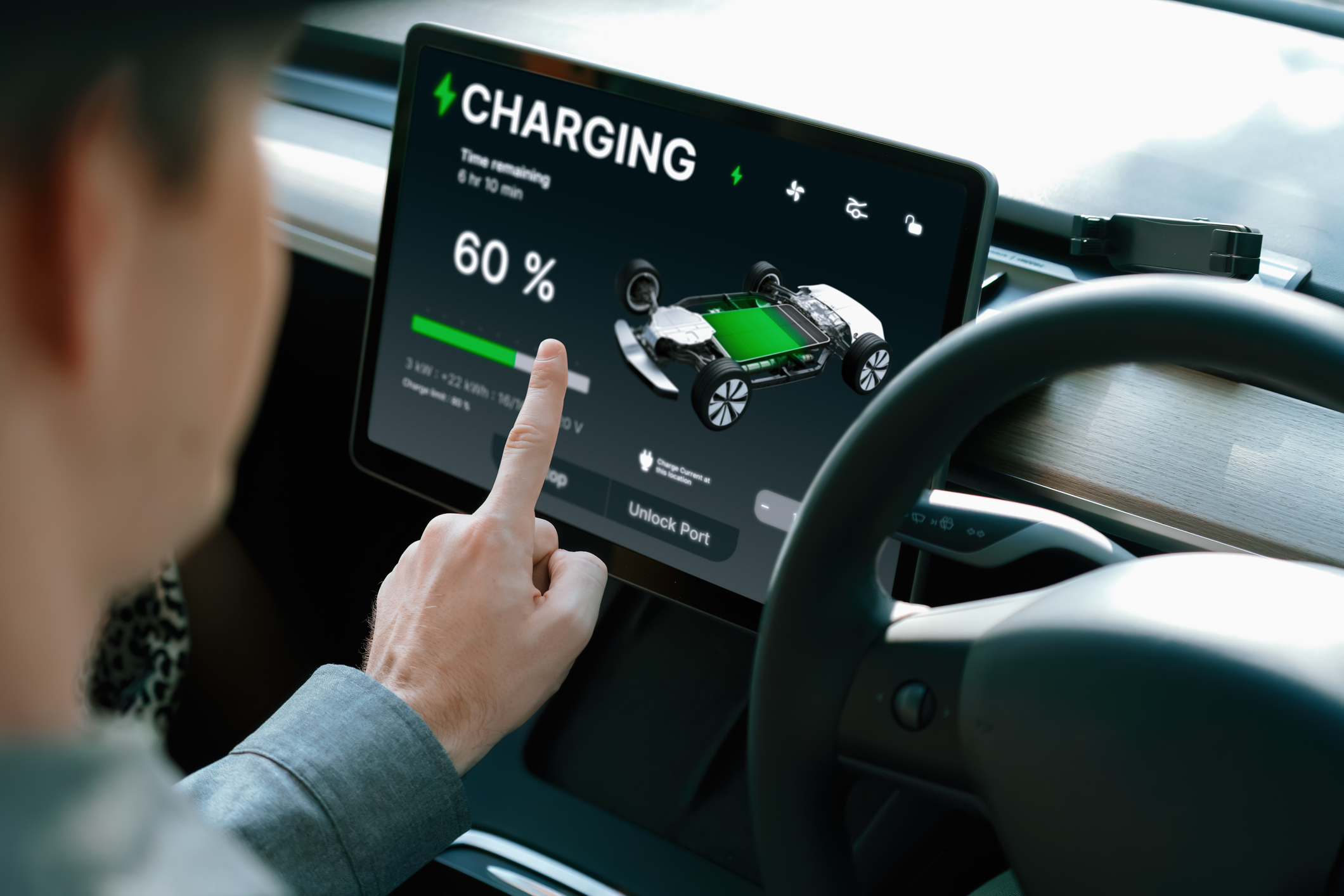 Le conducteur de voiture électrique vérifie l'état de charge de la batterie, l'autonomie et la limite de charge sur l'écran de l'application dans la voiture.