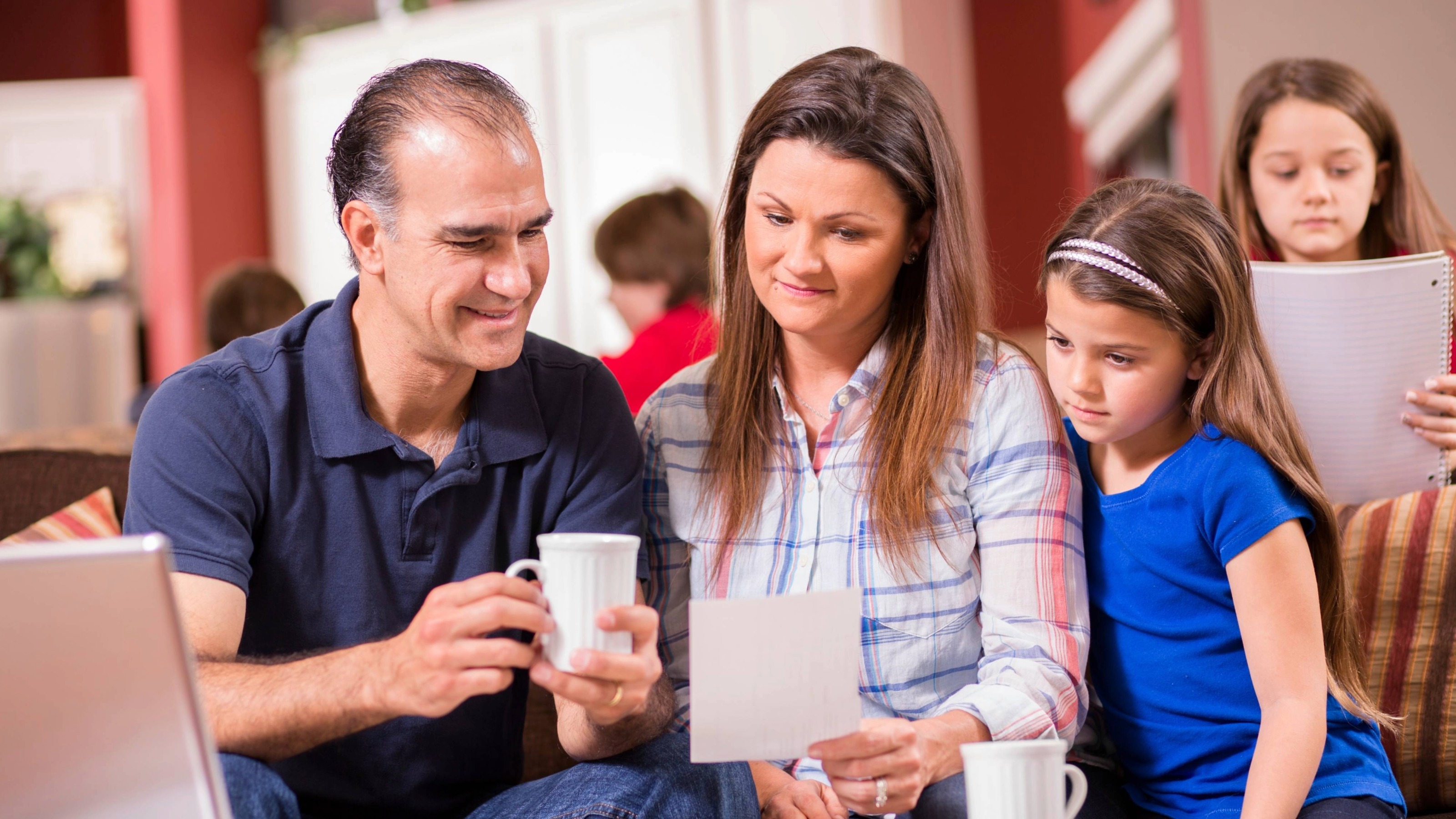 Maman, papa et enfant regardent un morceau de papier tandis que les autres enfants restent en arrière-plan