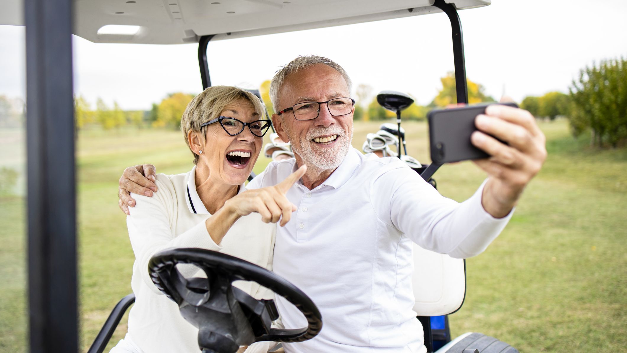 un couple prenant un selfie sur une voiturette de golf
