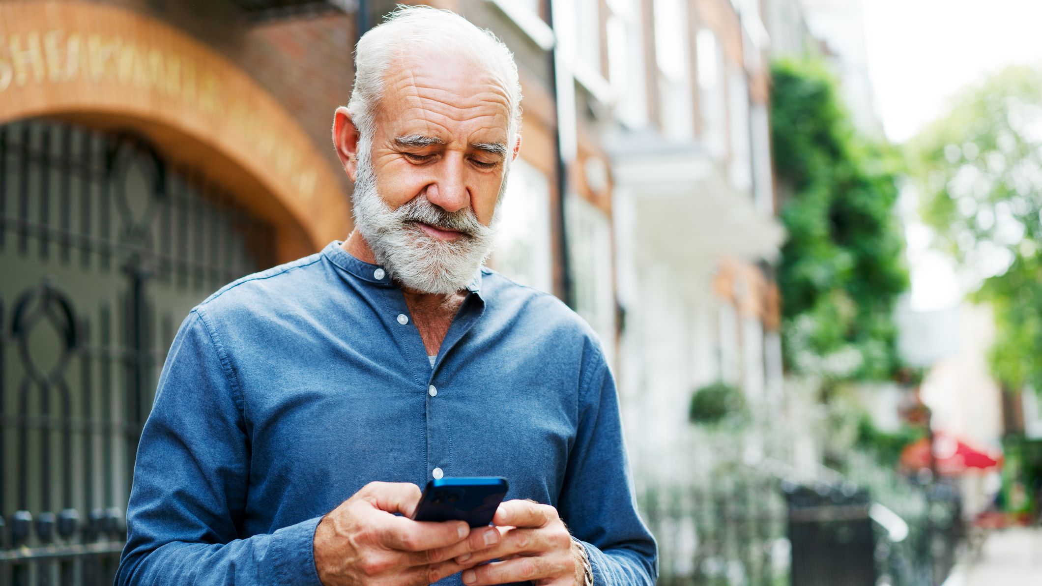 Homme utilisant un téléphone intelligent, souriant