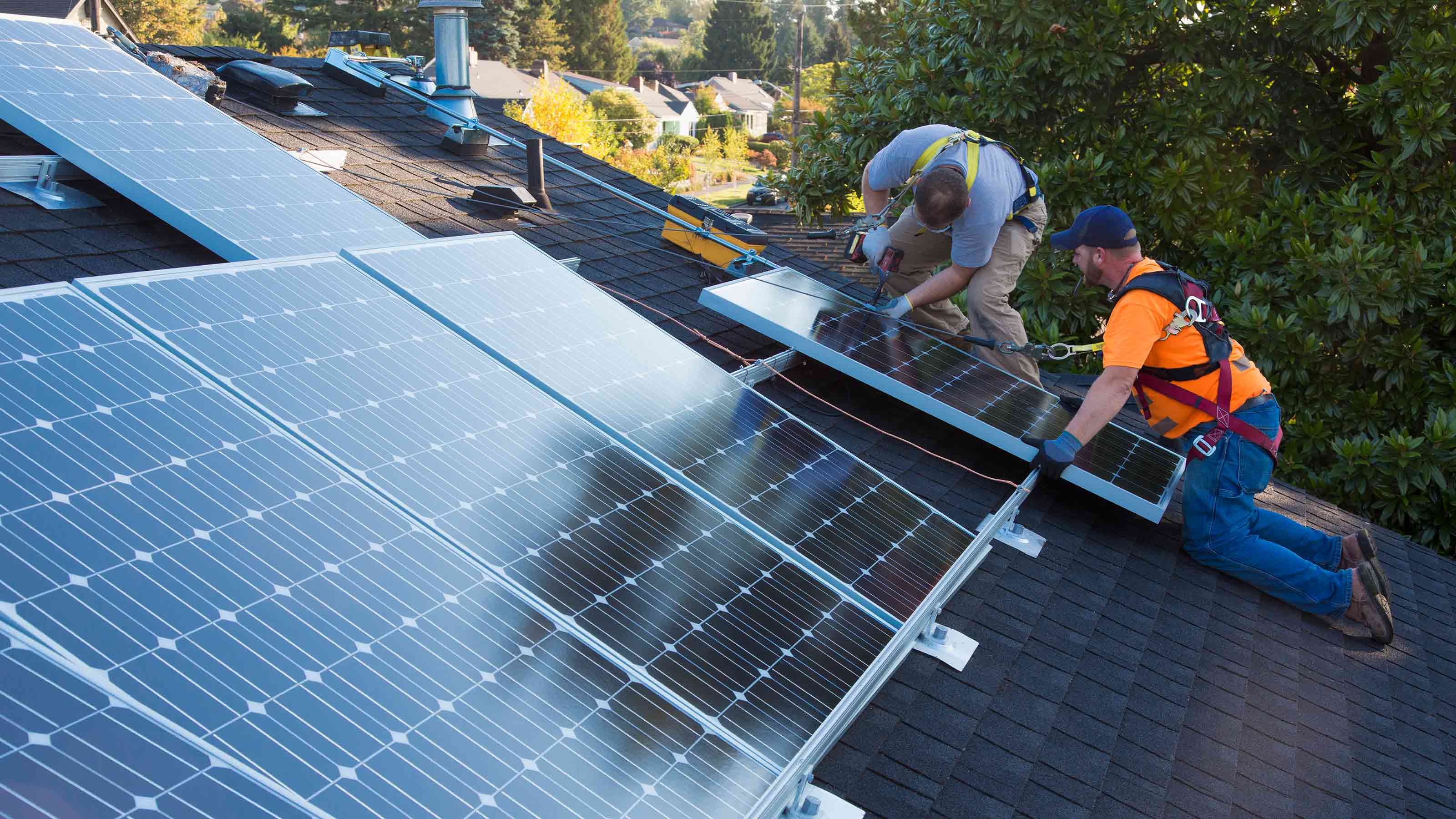 photo d'hommes installant des panneaux solaires sur un toit