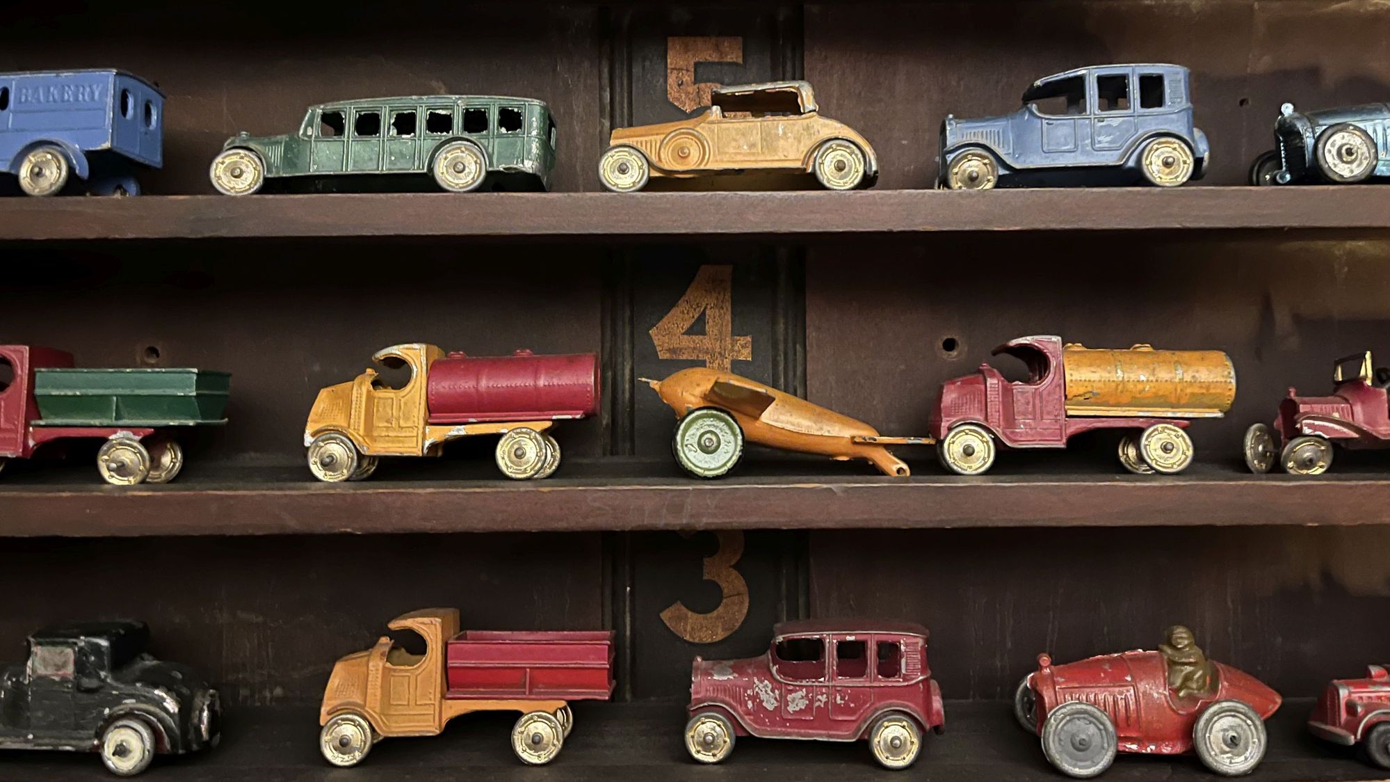 Voitures et camions jouets anciens. Voitures et camions jouets vintage des années 1920 sur des étagères.