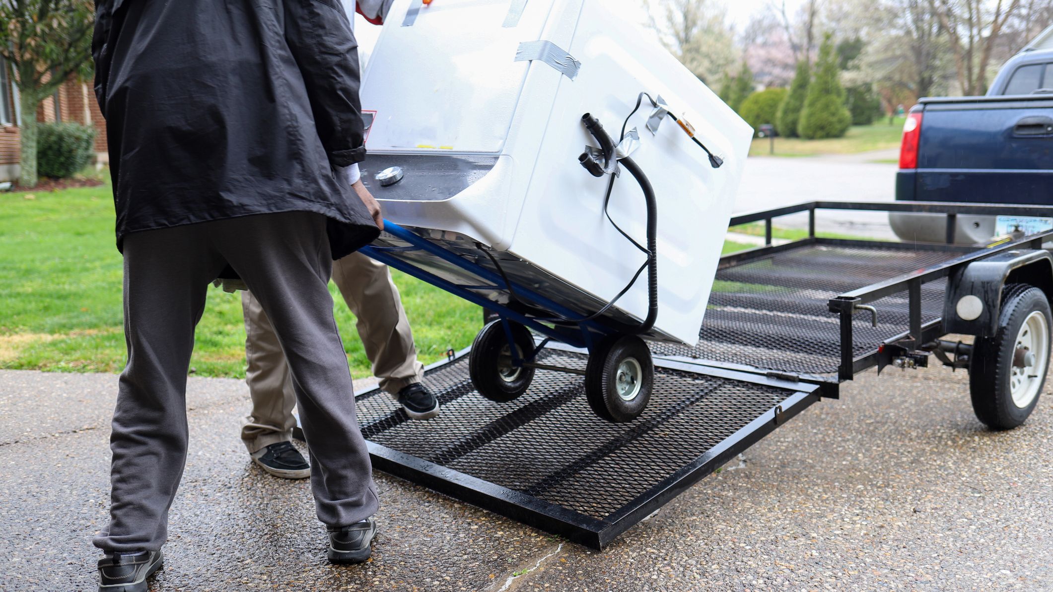 Deux hommes chargeant une laveuse à stocker.