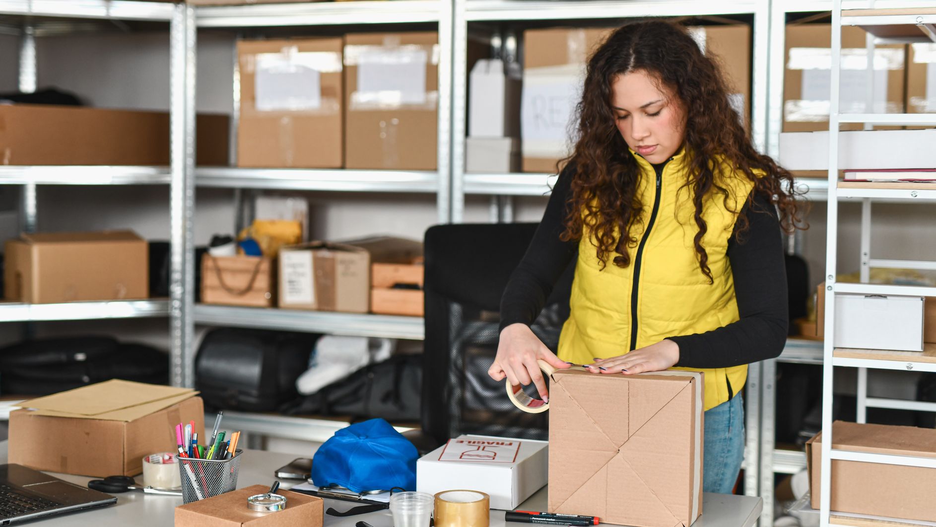 Une femme emballant un article vendu dans son unité de stockage.