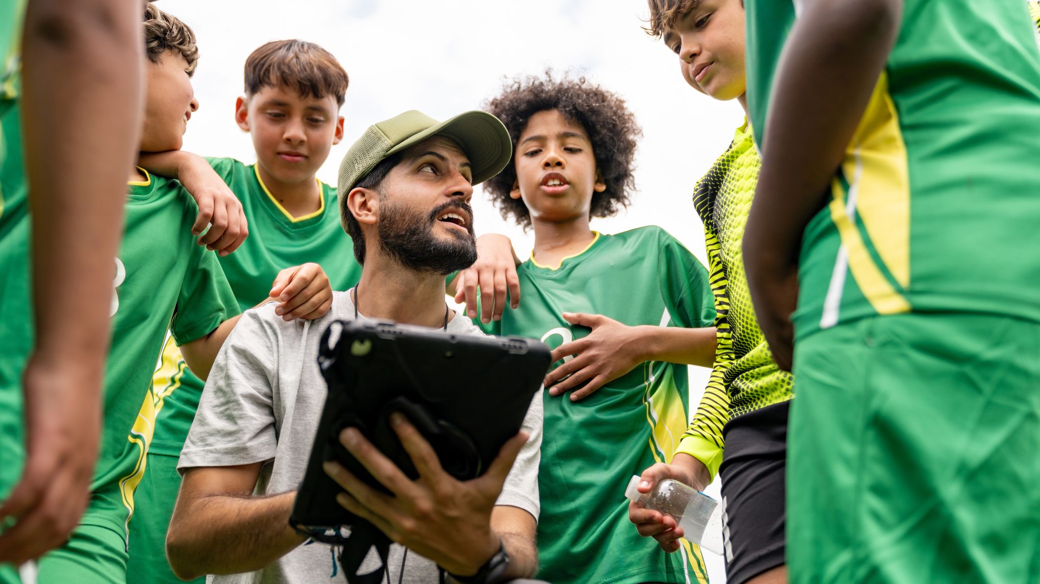 Entraîneur de football parlant à un groupe d'enfants pendant l'entraînement
