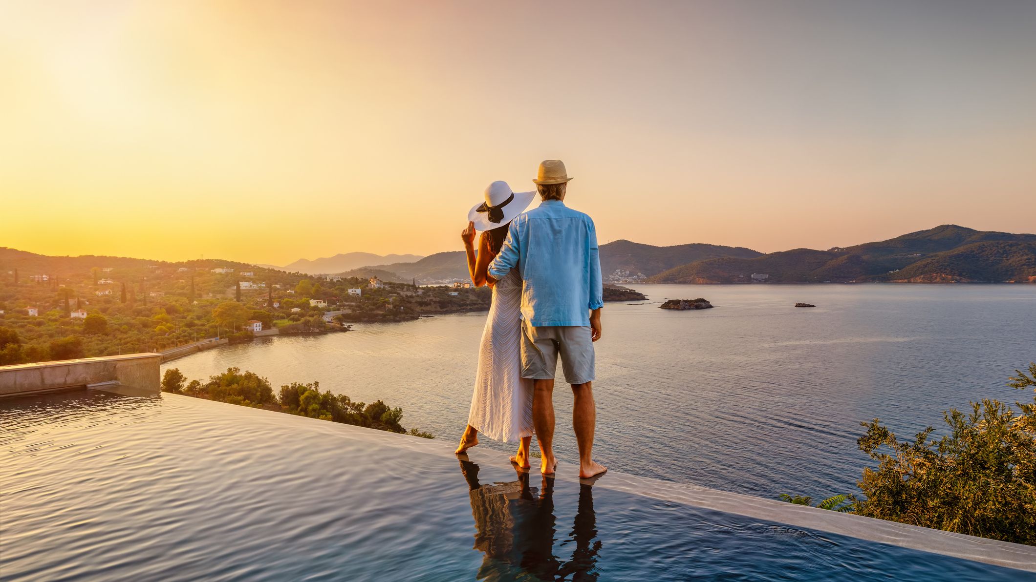 un couple profitant du coucher de soleil dans une piscine à débordement
