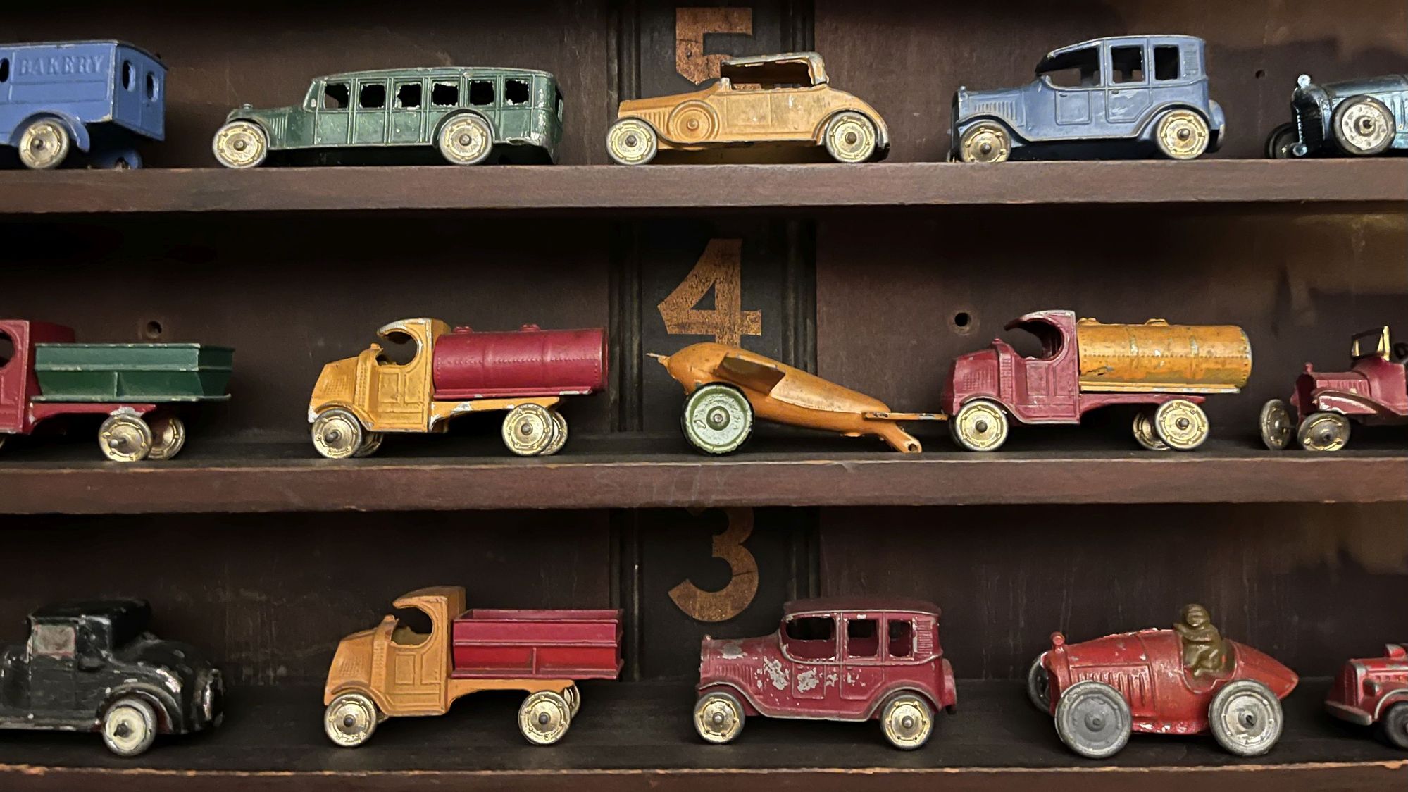 Voitures et camions jouets anciens. Voitures et camions jouets vintage des années 1920 sur des étagères.