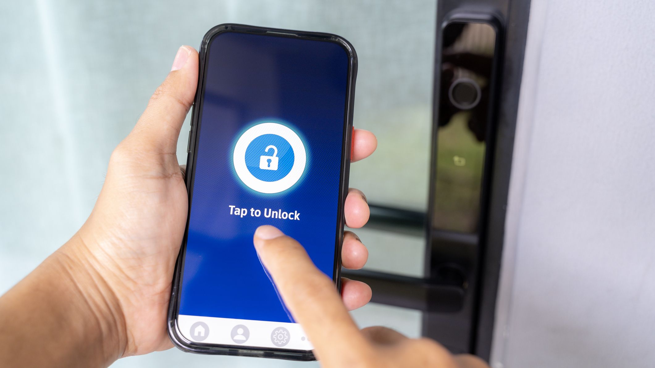 Main utilisant une application pour smartphone pour déverrouiller le système de porte de maison intelligente moderne