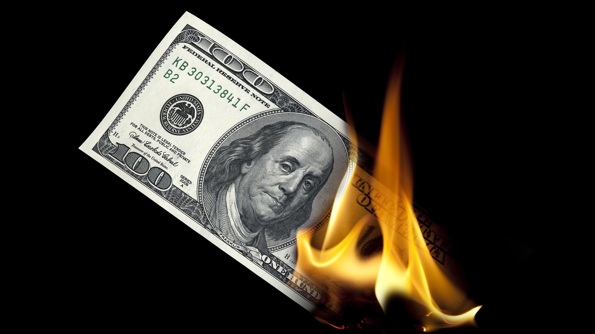 Un billet de cent dollars en feu.