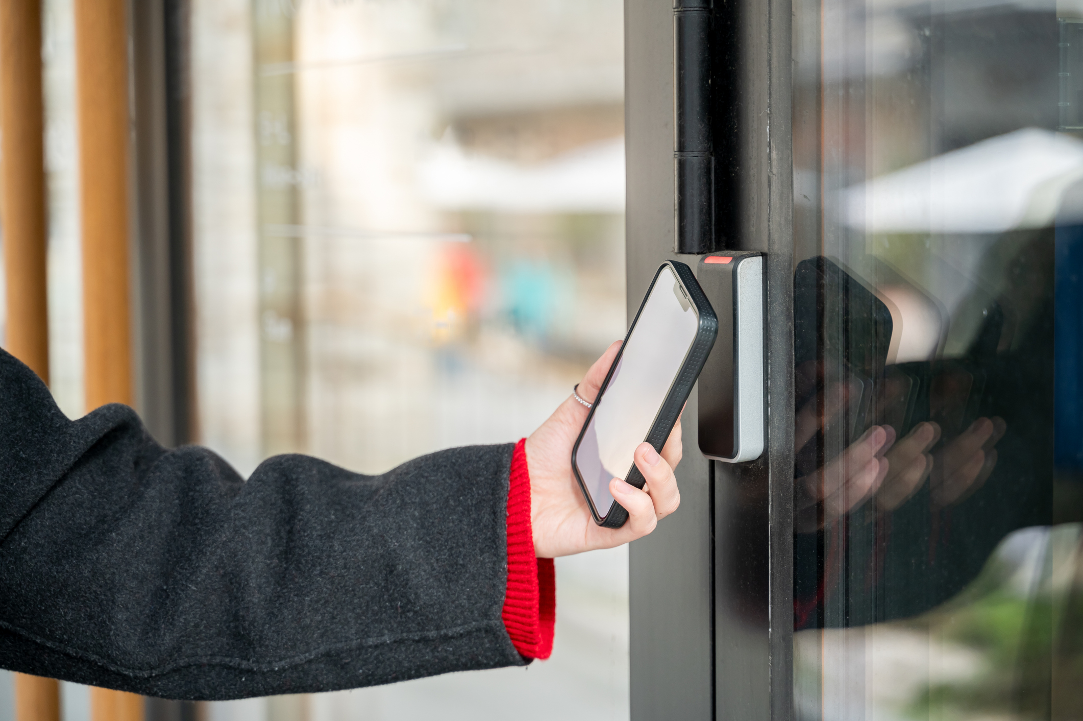 une personne utilisant son smartphone pour activer la serrure intelligente afin de déverrouiller la porte d'entrée