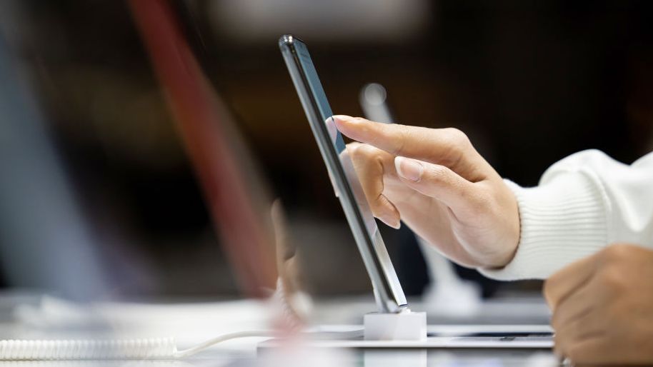 Une personne testant un smartphone en magasin.