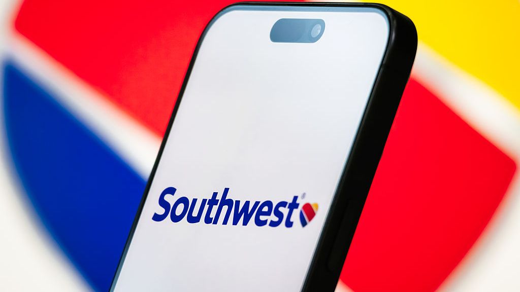 Sur cette illustration photographique, le logo de Southwest Airlines est affiché sur l'écran d'un smartphone, avec le cœur rouge, bleu et jaune de la société visible en arrière-plan.