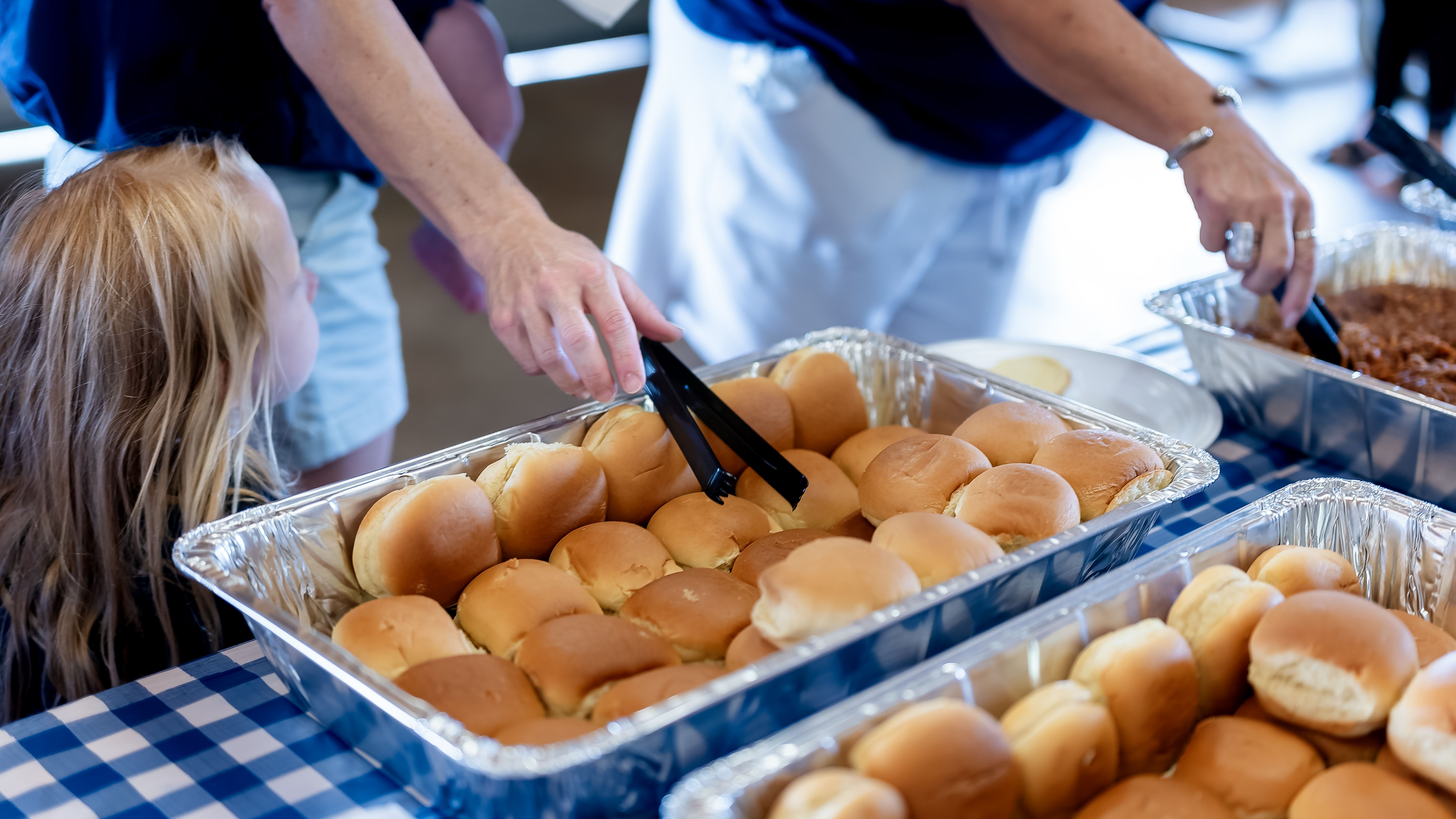 Des gens se servent de la nourriture sous forme de buffet lors d'une réunion de famille.