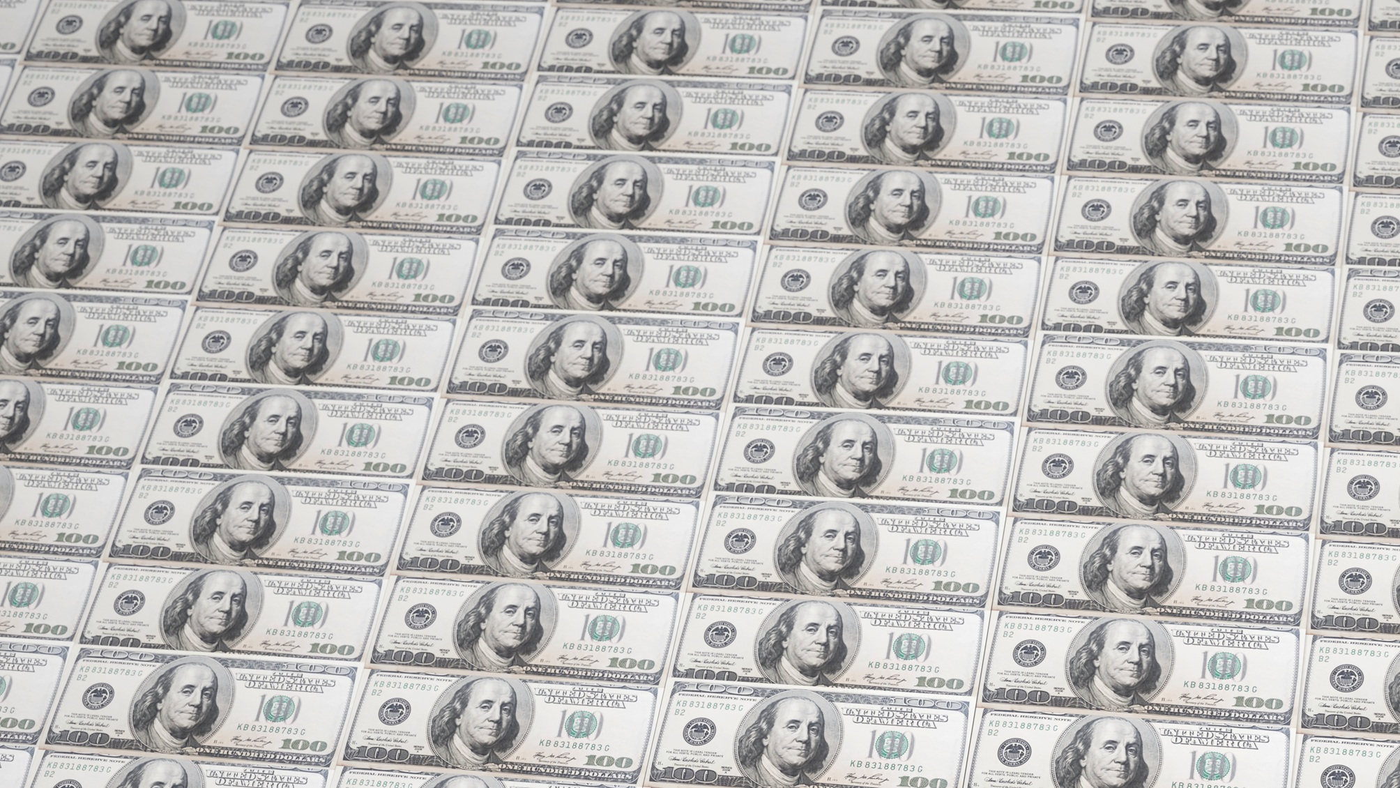Des billets de cent dollars posés bout à bout et de haut en bas.