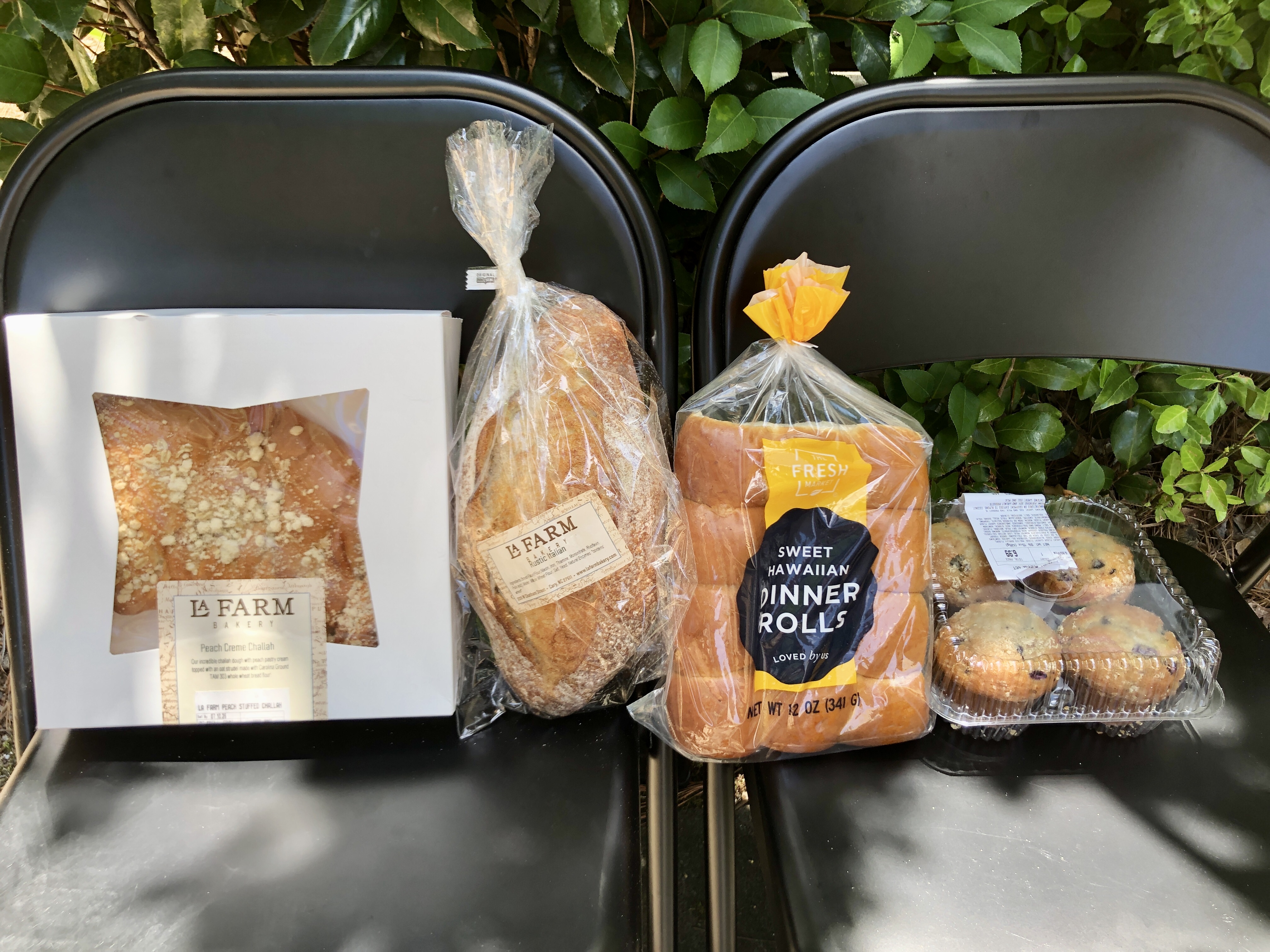 quatre produits de boulangerie sur deux chaises pliantes avec de la verdure derrière eux