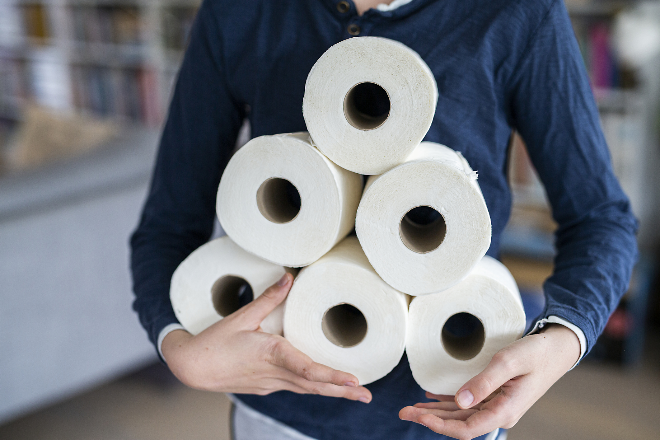 une personne tenant des rouleaux de papier toilette
