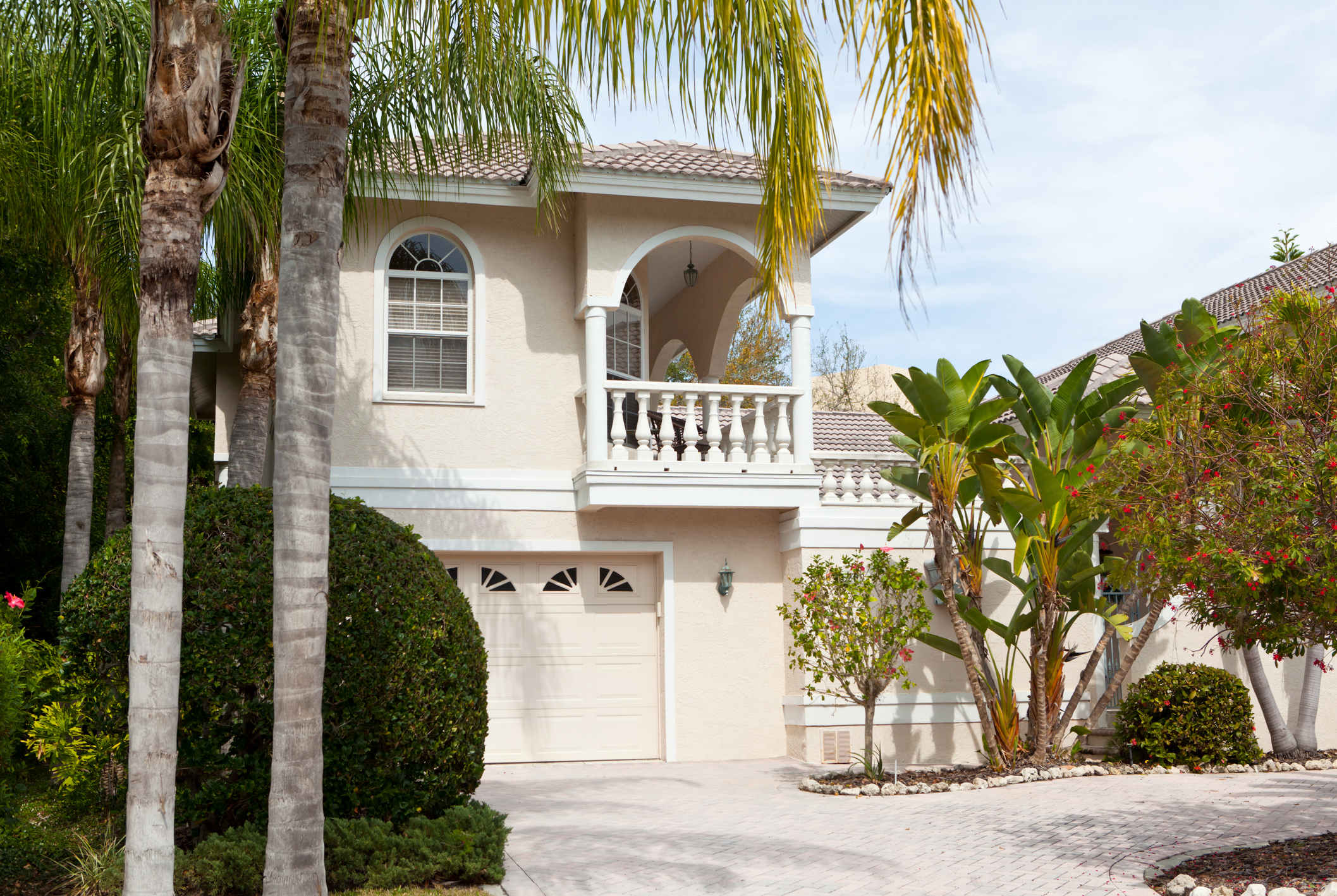 Villa de Floride beige clair avec palmiers et feuillage